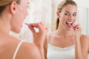 foto de uma mulher escovando os dentes.